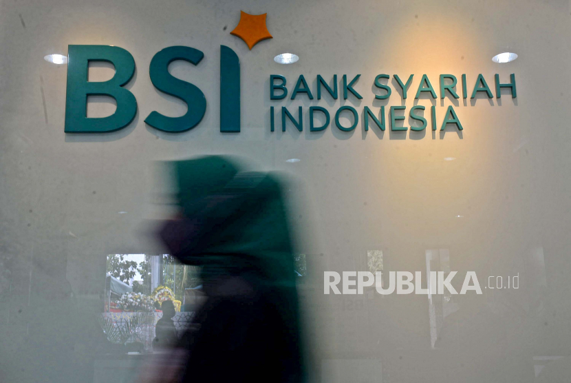 Karyawan melintas di dekat logo Bank Syariah Indonesia (BSI) KC Jakarta Barat